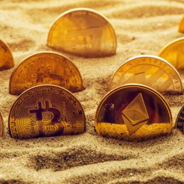 cryptocurrency coins in sand