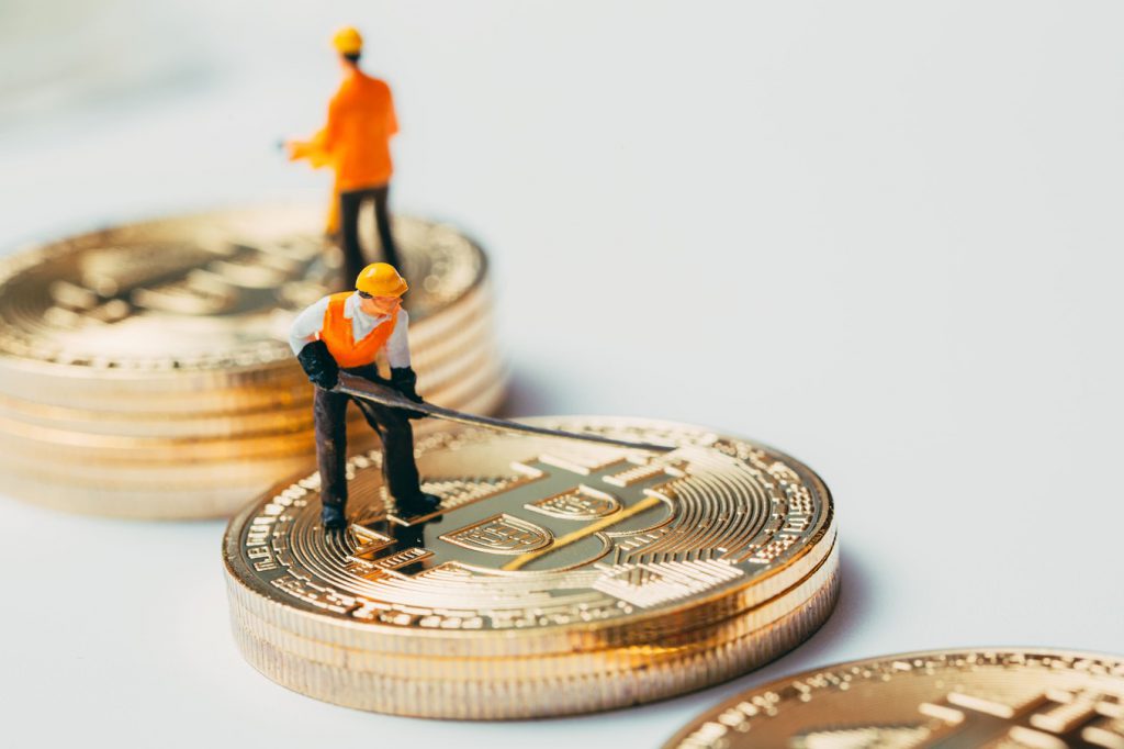 miniature worker working on bitcoin